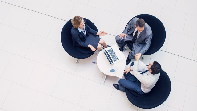 Three people in meeting lounge talking