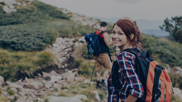 En yngre kvinne som går fottur i fjellet. 