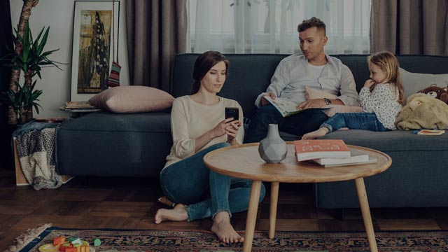 Family in couch looking at a mobile phone