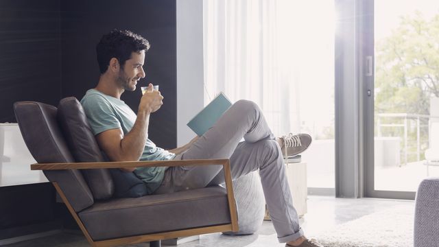 Man drinking tea and reading book