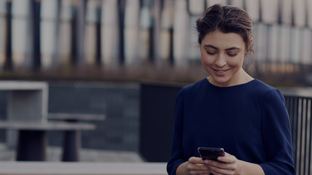 Woman sitting outside with phone.