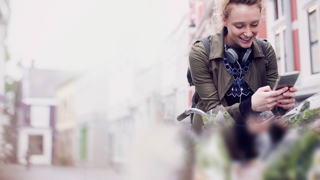 girl on bike looking at her mobile phone