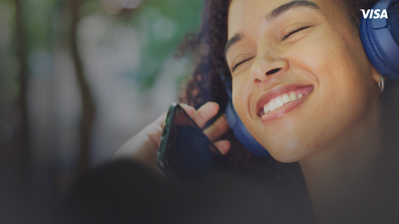 Jente med hodetelefoner med Spotify på sin mobil