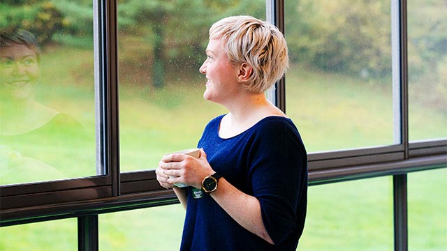 Nordea-kunde, Lise Fjellheim, har en kopp i hånden og ser ut av et vindu