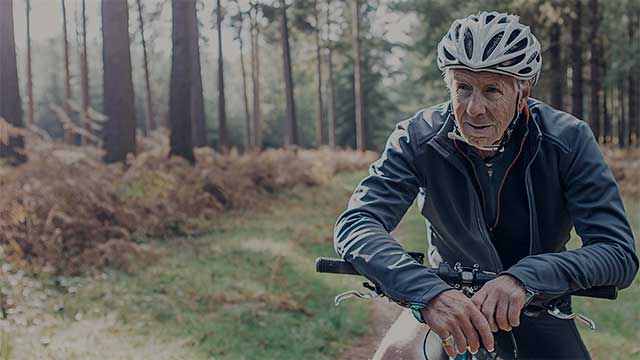 Senior male on bike in forest small overlay