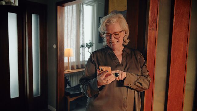 Woman watching mobile in house SMALL