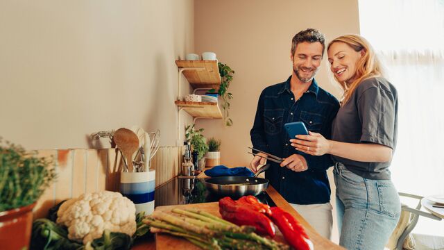 Woman and man in kitchen looking at phone SMALL