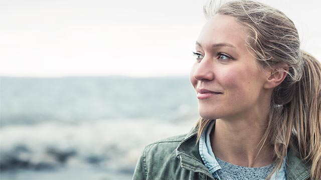 Ung kvinne som som ser utover vannet. 