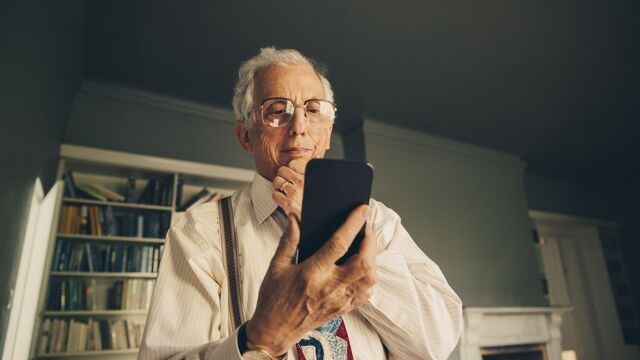 Older man looking at mobile curious