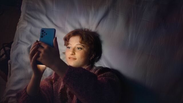 Woman in bed with phone SMALL