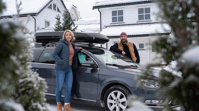 Couple standing by their car during winter-640x360