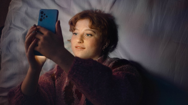 Woman-in-bed-with-phones-640x360