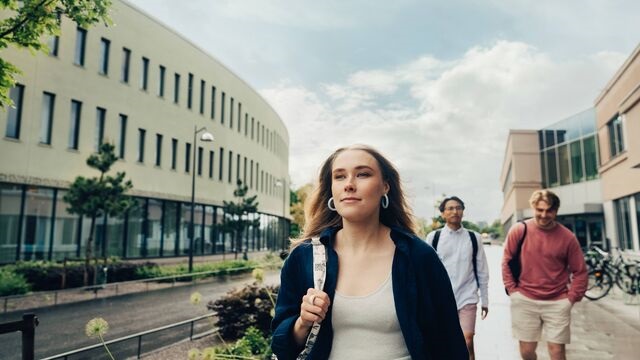 A group of student is walking across campus SMALL
