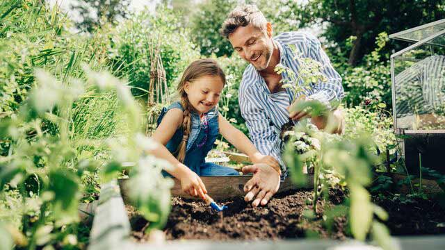 Et smilende barn utendørs som balanserer på den stein. 