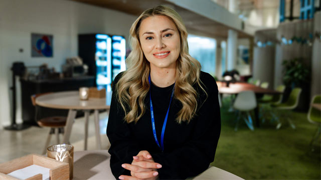 Isabella Biedrawa sitter ved et bord i Nordeas lokaler