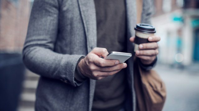 man drinking coffee and using mobile SMALL