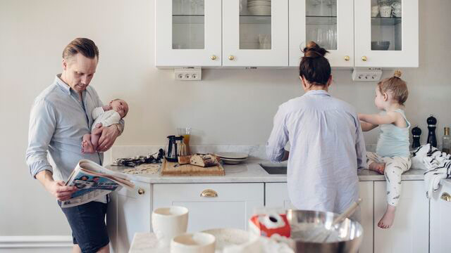 Familie som sitter sammen og ser på mobil.