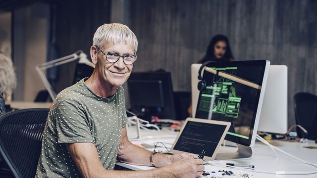 Nordea-xx-small-Smiling-male-engineer-with-laptop-at-desk-in-office