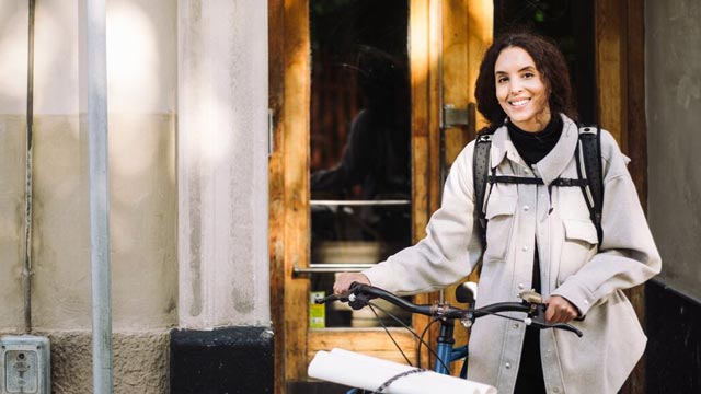 Ung mann med mobiltelefon står ved vinduet og ser ut