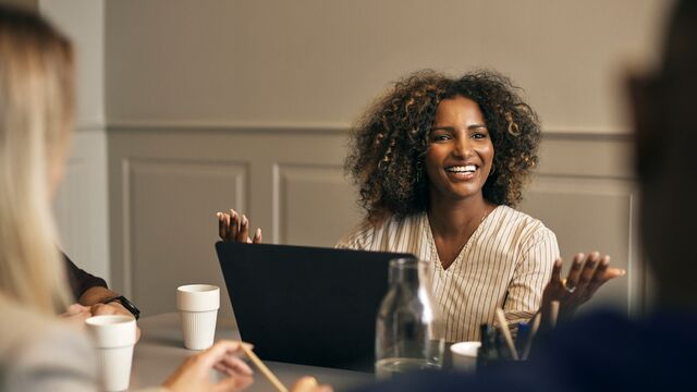 Woman-discussing-ideas-with-other-colleagues-at-a-meeting-table-small