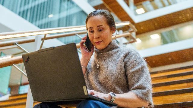 Bank woman working on computer whilst on the phone